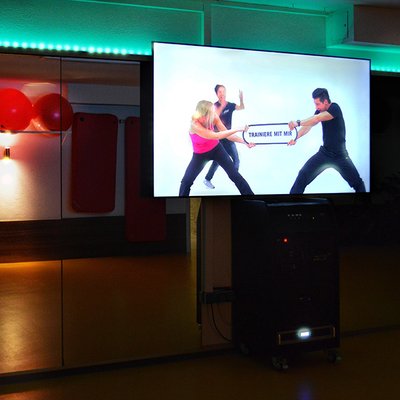TopFit Fitness- und Gesundheitszentrum - Feucht: Digital geführter Kurs mit Teilnehmer*innen im modernen Kursraum.